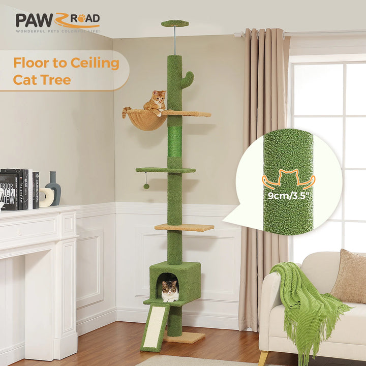 Arbre à chat vert du sol au plafond avec plateformes, niche, hamac suspendu et griffoir incliné, installé dans un salon lumineux avec rideaux beiges et parquet.